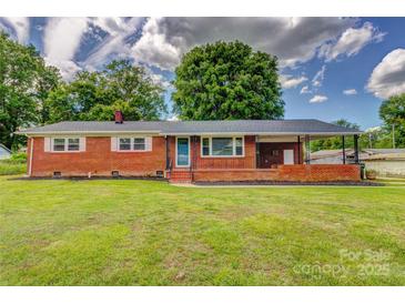 Charming brick home featuring a well-maintained lawn and covered porch, perfect for outdoor enjoyment at 413 N Mulberry St, Cherryville, NC 28021