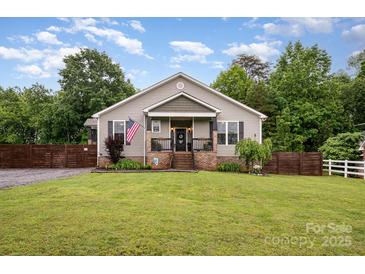Charming single-Gathering home boasts a well-manicured lawn and cozy, covered front porch with brick steps at 5252 Ramblewoods Ave, Claremont, NC 28610