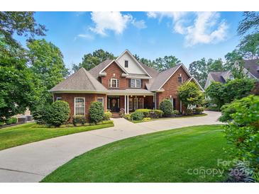 Beautiful two-story brick home with meticulously landscaped front yard and circular driveway at 5718 Bardsey Ct, Matthews, NC 28104
