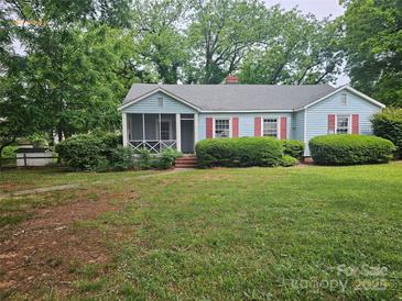 Charming single-story home with light blue siding, red shutters, and a cozy screened front porch at 6407 Market St, Charlotte, NC 28215