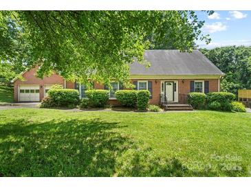 Charming brick home with manicured lawn and mature trees, offering classic curb appeal at 8017 Prince George Rd, Charlotte, NC 28210