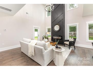 Bright living room featuring a modern fireplace, wood floors, and neutral decor at 9527 Walkers Ferry Rd, Charlotte, NC 28214