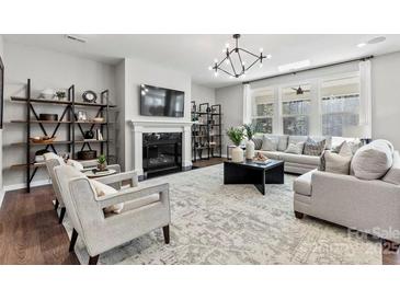Bright living room featuring a fireplace, modern lighting, and comfortable seating arrangement at 1102 Sugar Creek Rd, Indian Land, SC 29707