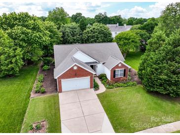 Aerial view of a charming brick and white home with well-manicured lawn and mature trees at 11332 Ridge Oak Dr, Charlotte, NC 28273