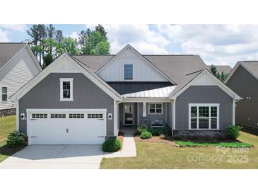 Charming home featuring a gray shingle exterior, white trim, well-manicured landscaping, and a welcoming front porch at 1360 Dali Blvd, Mount Holly, NC 28120