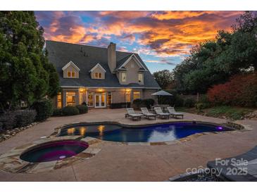 Beautiful backyard with a luxurious pool, lounge chairs, and a spacious patio area, perfect for outdoor entertaining at 18823 Peninsula Cove Ln, Cornelius, NC 28031