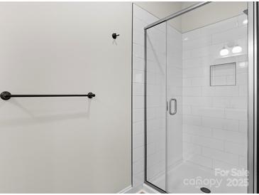 Modern bathroom features a glass-enclosed shower with white subway tile and black hardware at 3220 Riley Ave, Charlotte, NC 28269