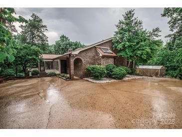 Charming brick home featuring an arched entryway, skylight, and beautiful landscaping on a wooded lot at 3700 Nw Gainesway Nw Ct, Concord, NC 28027