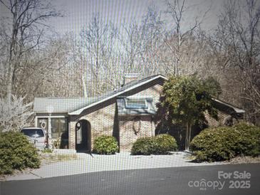 Exterior view of a single-story brick house surrounded by mature trees and bushes at 3700 Nw Gainesway Nw Ct, Concord, NC 28027