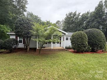 Charming single-story home with well-maintained lawn and mature landscaping creates inviting curb appeal at 400 Archibald Rd, Concord, NC 28025