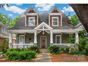 Charming two-story home features a covered porch, lush landscaping, and inviting curb appeal at 417 N Dotger Ave, Charlotte, NC 28204