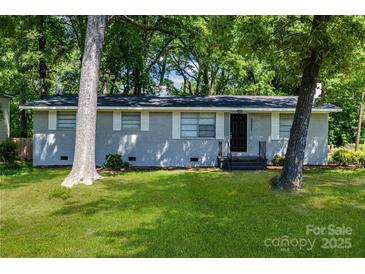 Charming single-story home with a gray painted brick exterior, well-maintained lawn, and mature trees at 5221 Wales St, Charlotte, NC 28269