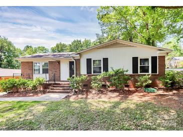 Charming single-story home featuring a brick facade, white siding, and well-manicured landscaping at 6517 Paleface Pl, Charlotte, NC 28214