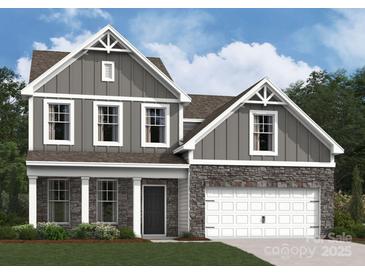 Charming two-story home with gray siding, stone accents, white trim, and a two-car garage at 905 Barker St, Monroe, NC 28112
