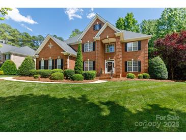 Stately brick home featuring manicured lawn, mature trees, and classic architectural details at 905 Patricians Ln, Monroe, NC 28110