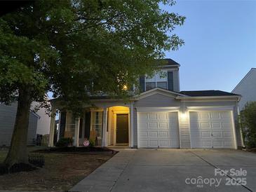 Charming two-story home with a two-car garage, inviting front porch, and manicured lawn at 10901 Claude Freeman Dr, Charlotte, NC 28262