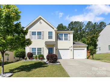 Charming two-story home with a well-manicured lawn and two-car garage on a sunny day at 1125 Jasmine Dr, Fort Mill, SC 29707