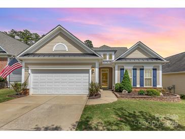 Charming home featuring a two-car garage, tidy lawn, and colorful landscaping, all beneath a beautiful sunset sky at 2035 Moultrie Ct, Fort Mill, SC 29707