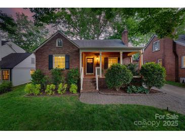 Charming brick home with a cozy front porch and manicured landscaping creating lovely curb appeal at 2124 Chambwood Dr, Charlotte, NC 28205