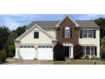 Two story home with a two car garage, brick facade, and manicured lawn at 2330 Winthorp Ridge Rd, Charlotte, NC 28270