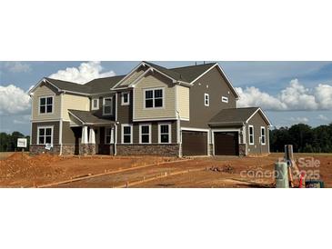 Charming two-story home featuring a two-car garage and a mix of stone and siding accents at 2522 Mabel Ln, Monroe, NC 28110