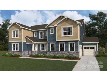 Craftsman elevation home with two-tone siding, stone accents, manicured lawn, and an attached two-car garage at 2522 Mabel Ln, Monroe, NC 28110