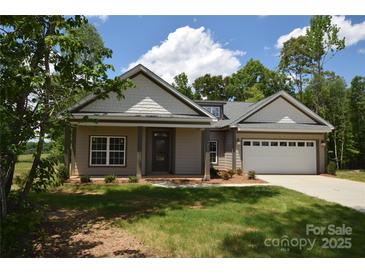 Charming single-story home with a two-car garage and a well-manicured lawn on a sunny day at 3011 Buffett Ln # 33, Monroe, NC 28110