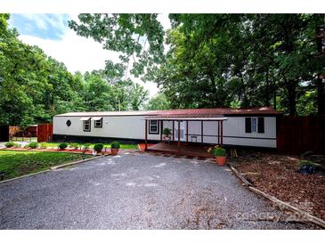 Charming single-story home featuring a covered porch, gravel driveway, and mature landscaping at 475 Dot Faris Rd, Catawba, SC 29704