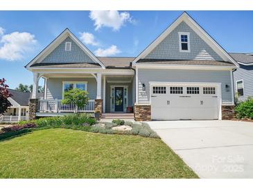 Charming home featuring a manicured lawn, welcoming front porch, and attached two-car garage at 6136 Sandy Point Ln, Belmont, NC 28012