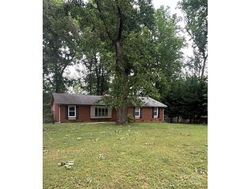 Charming brick home featuring a large, grassy front yard with mature trees offering ample shade at 6419 Prett Ct, Charlotte, NC 28270