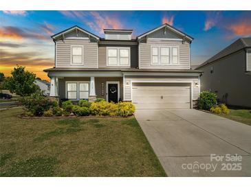 Charming two-story home featuring a well-manicured lawn, welcoming front porch, and a convenient two-car garage at 7318 Rupell Dr, Charlotte, NC 28273