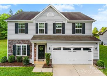Charming two-story home featuring gray siding, stone accents, and a well-maintained front yard at 865 Wingthorn Rose Dr, Gastonia, NC 28056