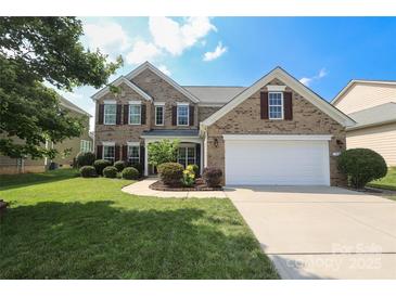 Charming two-story brick home with a well-manicured lawn and a two-car garage at 10217 Falling Leaf Dr, Concord, NC 28027