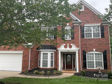 Charming two-story brick home with a manicured front yard, black shutters, and inviting entrance at 13123 Ashley Meadow Dr, Charlotte, NC 28213