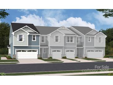 New construction townhomes with white trim, blue and gray siding, and two car garages in a contemporary style at 2027 Vinyasa Ln # Sts-40, Charlotte, NC 28215