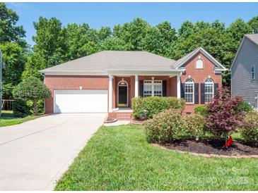 Charming brick home with a well-manicured lawn and beautiful landscaping at 4028 Garden Oak Dr, Indian Trail, NC 28079