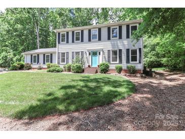Charming two-story home with a manicured lawn and a lovely blue front door and mature trees at 417 Florence Cir, Statesville, NC 28625
