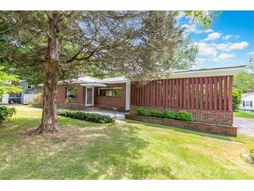 Charming brick home featuring mature landscaping, a welcoming entrance, and a well-maintained lawn at 1102 E 13Th St, Kannapolis, NC 28083