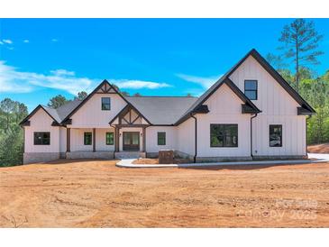 New construction home boasts a white exterior with dark trim, set against a bright blue sky at 124 Starboard Ln, Statesville, NC 28677
