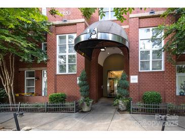 Inviting brick building entrance with awning and manicured landscaping offering a warm welcome at 1320 Fillmore Ave # 426, Charlotte, NC 28203