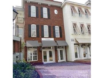 Charming townhouse exterior with brick facade, black shutters, and awnings over storefront entrances at 2092 Ayrsley Town Blvd, Charlotte, NC 28273
