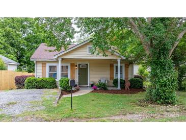 Charming single-story home with light yellow siding, quaint front porch, and mature landscaping at 2212 Acme Rd, Belmont, NC 28012
