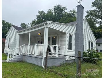 Charming single-story home with a covered front porch, white siding, and a brick chimney at 247 E Cabarrus Ave, Concord, NC 28025