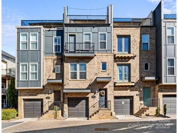 Modern brick townhomes featuring a rooftop terrace, balconies, individual garages, and manicured landscaping at 2863 Grand Union Way, Charlotte, NC 28209
