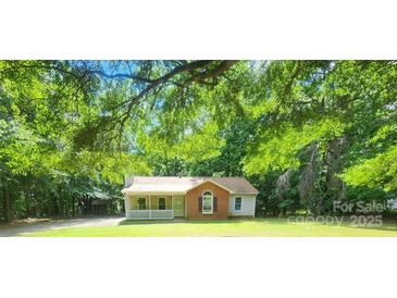 Charming single-Gathering home featuring a cozy front porch and a brick facade surrounded by mature trees at 4409 Homestead Rd, Rock Hill, SC 29732