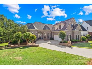 Stunning brick home features a circular driveway, mature trees, and lush landscaping at 458 Inverness Pl, Rock Hill, SC 29730