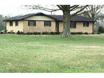 Single story home with brick and siding exterior, dark shutters, and a large front yard at 1120 Mcintyre Rd, Wingate, NC 28174