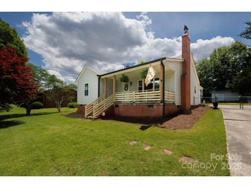 Charming home featuring a brick chimney, inviting front porch, and well-maintained lawn at 1423 N New Hope Rd, Gastonia, NC 28054