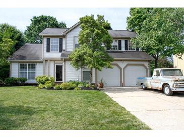 Charming two-story home featuring a manicured lawn, mature landscaping, and a two-car garage with a vintage pickup truck at 14406 Gadwall Ct, Charlotte, NC 28273