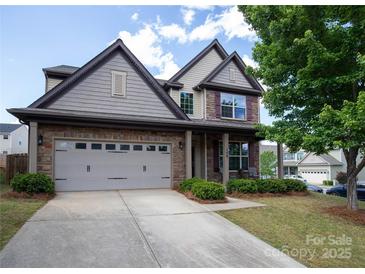 Charming two-story home featuring a brick and siding facade, attached two car garage, and well manicured landscaping at 159 Saye Pl, Mooresville, NC 28115